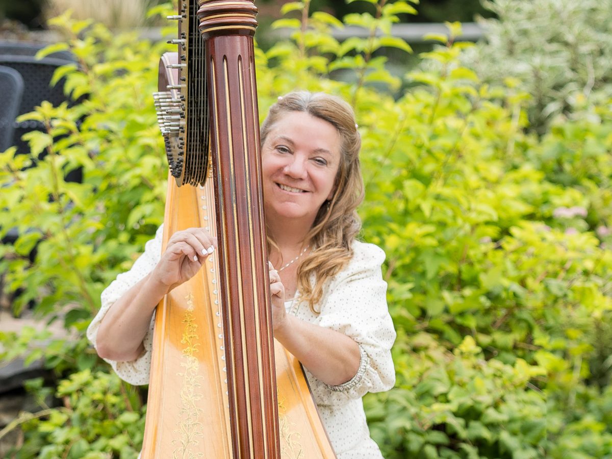 Patricia Turse smiling from behind her pedal harp