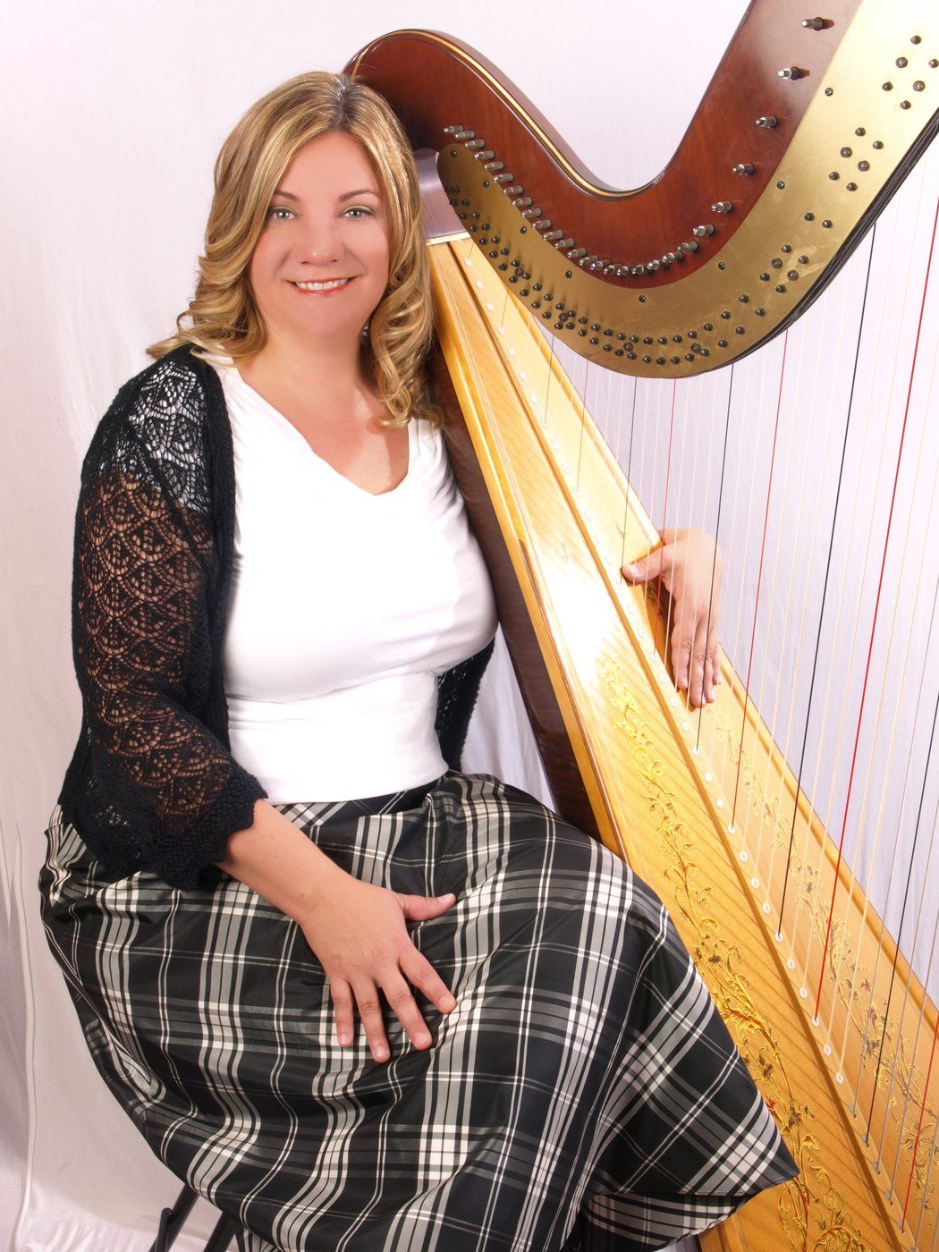 Patricia Turse seated at her full-size pedal harp