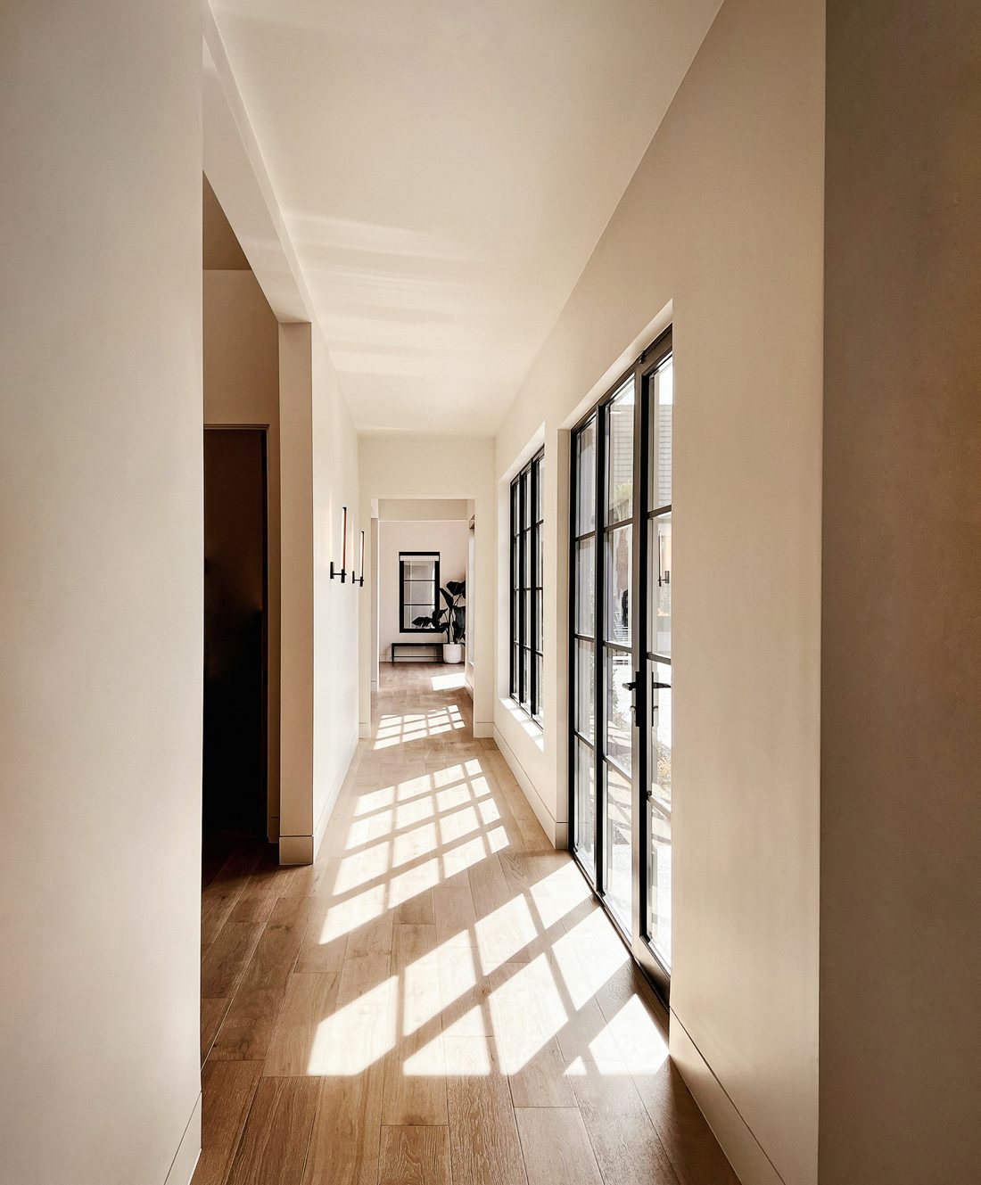 A sunlit corridor with light falling across a wooden floor